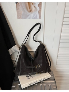 Détail d'un sac cabas en cuir souple avec surpiqûres contrastées et boucles décoratives