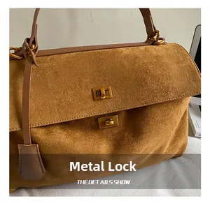Detailed close-up of brown suede material with two golden rectangular metal locks