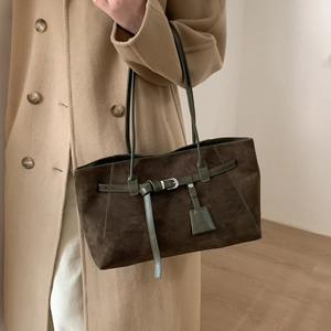 Detail of dark brown suede tote bag featuring green leather straps and silver buckle