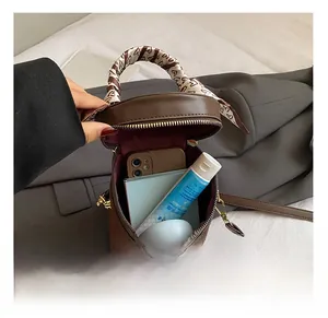 Internal capacity of brown leather bucket bag with silk scarf handle and daily essentials