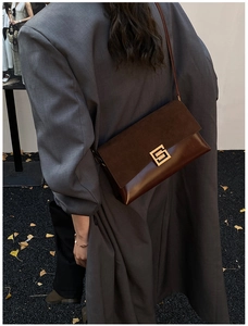Detail of vintage coffee brown shoulder bag featuring suede patchwork and gold buckle