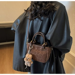 Sac cabas léopard en daim marron avec détail d'un petit ours en peluche sur la lanière
