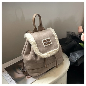 Detail of frosted suede backpack with plush fleece trim and brown bear leather patch