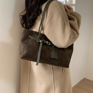 Detail of dark brown suede tote bag with olive green straps and silver metal buckle