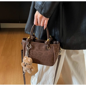 Détail du sac cabas imprimé léopard marron foncé avec finition mate et breloque