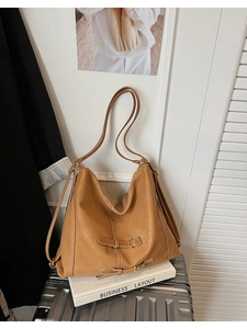 Détail d'un sac cabas en cuir marron avec boucle en métal et coutures texturées