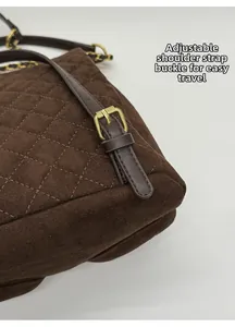 Close-up of golden adjustable strap buckle on vintage brown quilted suede backpack