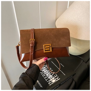 Detail of vintage brown shoulder bag showing suede texture and golden metal buckle