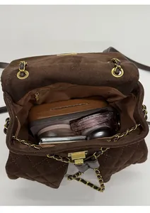 Interior view of brown quilted chain bag showing capacity for glasses and cosmetics