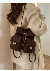 Close-up of retro quilted brown suede backpack with gold twist locks and chain straps