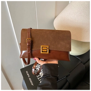 Detail of vintage brown flap bag with suede texture and golden metallic buckle