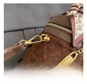Detailed view of brown quilted suede bucket bag with gold hardware and silk scarf