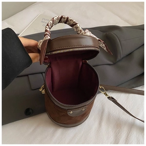 Detail view of the deep burgundy lining and spacious interior of the brown bucket bag