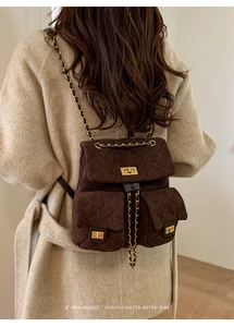 Close-up of brown quilted suede backpack featuring golden chain straps and turn-locks
