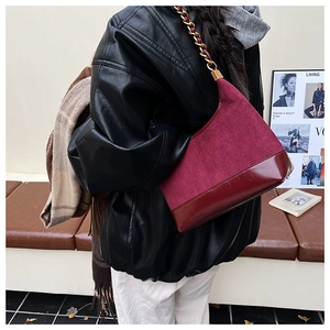 Macro shot of burgundy matte suede and glossy faux leather patch details on a stylish bag