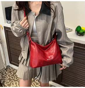 Detailed view of a vintage red leather shoulder bag on a model in a stylish commute setting