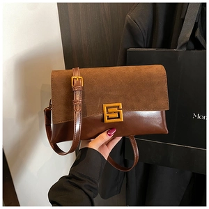 Close-up of retro brown patchwork shoulder bag with elegant gold geometric metal buckle