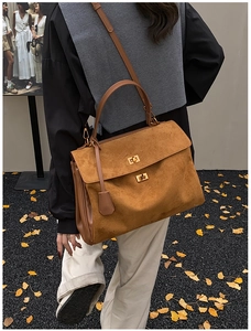 Detail of vintage tan suede tote bag with dual metal twist locks and textured finish