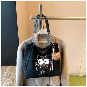 Détail du sac cabas en suède noir avec motif chat et charmant pendentif ours en peluche