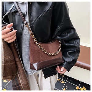 Detail of dark brown patchwork Hobo bag with metal chain and suede leather texture