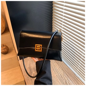 Detail of minimalist black patent leather bag with vintage golden geometric lock buckle