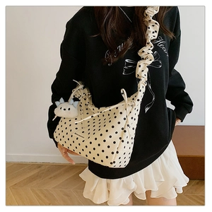 Detail of cream polka dot crossbody bag with pleated strap and cute cloud plush charm