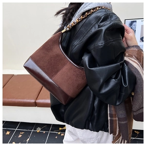 Detail of vintage patchwork shoulder bag in brown suede and leather with gold chain
