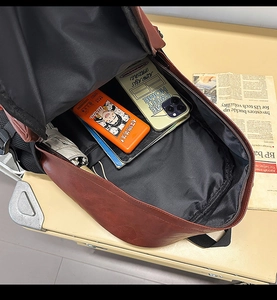 Macro view of spacious main compartment in a brown PU leather backpack with essentials