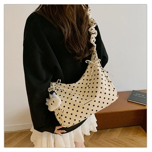 Detail of cream polka dot shoulder bag with ruffled strap and cute sheep charm