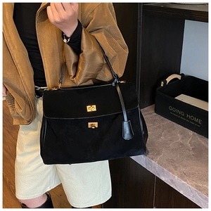 Detail showing the vintage black suede tote bag with elegant golden dual twist locks