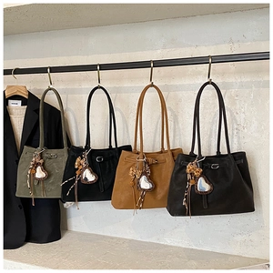 Reihe großer Wildleder-Tote-Bags in Grün Schwarz und Braun mit Leoparden-Anhängern