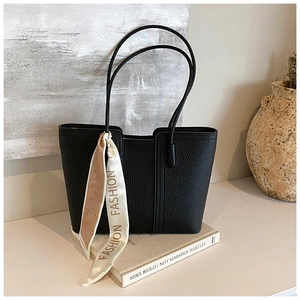 Detail der schwarzen Tote Bag mit Litschiprägung und dekorativem Modeschal