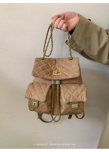 Close-up of diamond quilted suede backpack with golden twist lock and metal chain straps