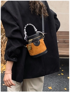 Detail of quilted bucket bag with brown suede finish and silk scarf wrapped handle