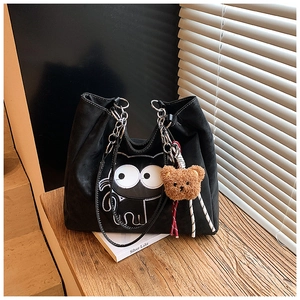 Détail du sac cabas en daim noir avec broderie chat et pendentif ours en peluche