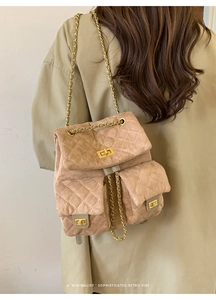 Detail of khaki suede quilted backpack with golden twist lock and chain strap