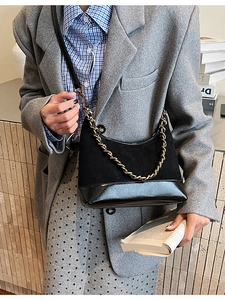 Matte and patent leather half-moon shoulder bag with bold gold chain accessory
