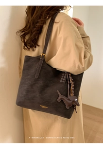 Detail of vintage dark brown tote bag with leather charms and adjustable shoulder strap