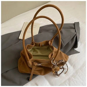 Detailansicht der camel-farbenen Suede Tote Bag mit Herzanhänger und grünem Futter