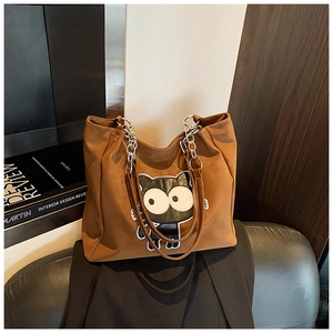 Détail du sac cabas marron avec broderie chat et bandoulière en chaîne élégante