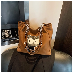 Détail du sac cabas marron avec écusson chat cartoon et bandoulière en chaîne métal