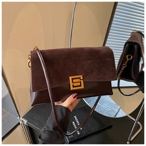 Detailed mirror view of dark brown leather shoulder bag with gold square buckle