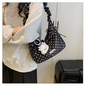 Detail of polka dot shoulder bag with ruffled strap and plush cartoon pendant