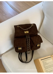 Detail of quilted brown suede backpack with gold metal twist lock and chain strap details