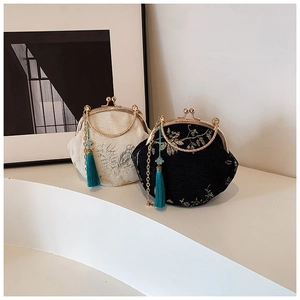 Detail of embroidered silk shell bags with metal ring handles and long blue tassels