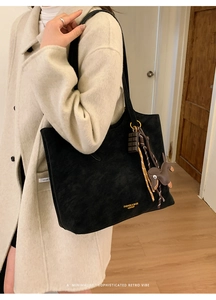 Detail of black matte tote bag with golden lettering and creative chocolate charms