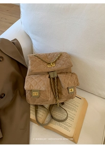 Detailed macro view of khaki faux suede quilted backpack with golden chain accents