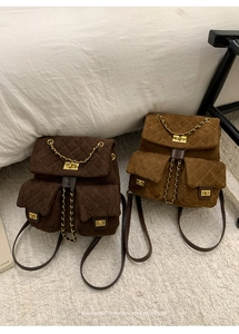Detail of quilted suede backpacks with gold twist locks and retro chain straps