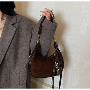 Vue détaillée du sac hobo café avec pendentif ours et accessoires en métal doré