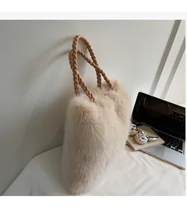 Detail of soft beige faux fur tote bag showing the textured leather braided handle in focus